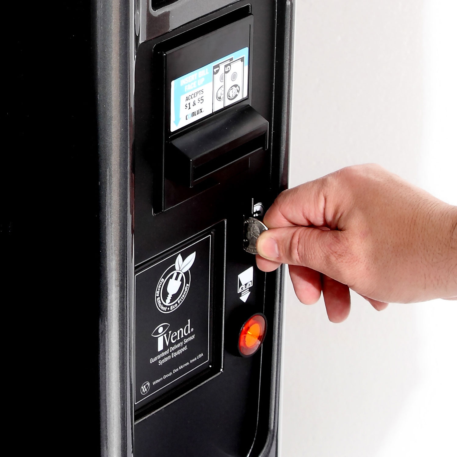 A customer paying for their product using a coin through the coin acceptor on a vending machine.