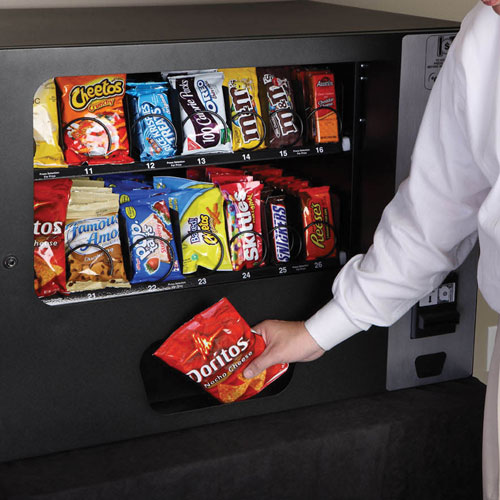 Customer retrieving a Doritos snack from a tabletop snack vending machine from Selectivend.