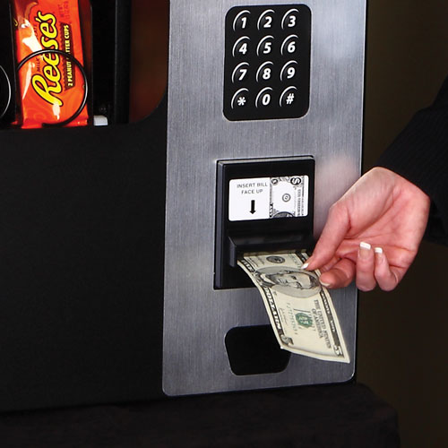Customer purchasing a product with a $5 bill from a the Table Top Snack Vending Machine.