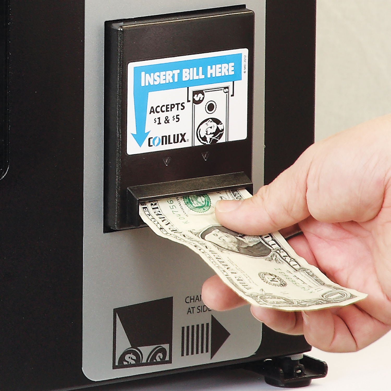 Customer inserting a $1 bill into a vending machine using the standard bill acceptor.